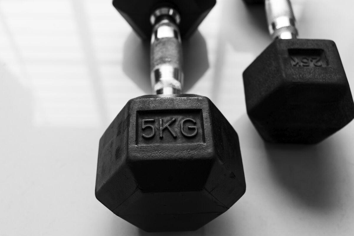 Henkilö kuntosalilla painojen kanssa