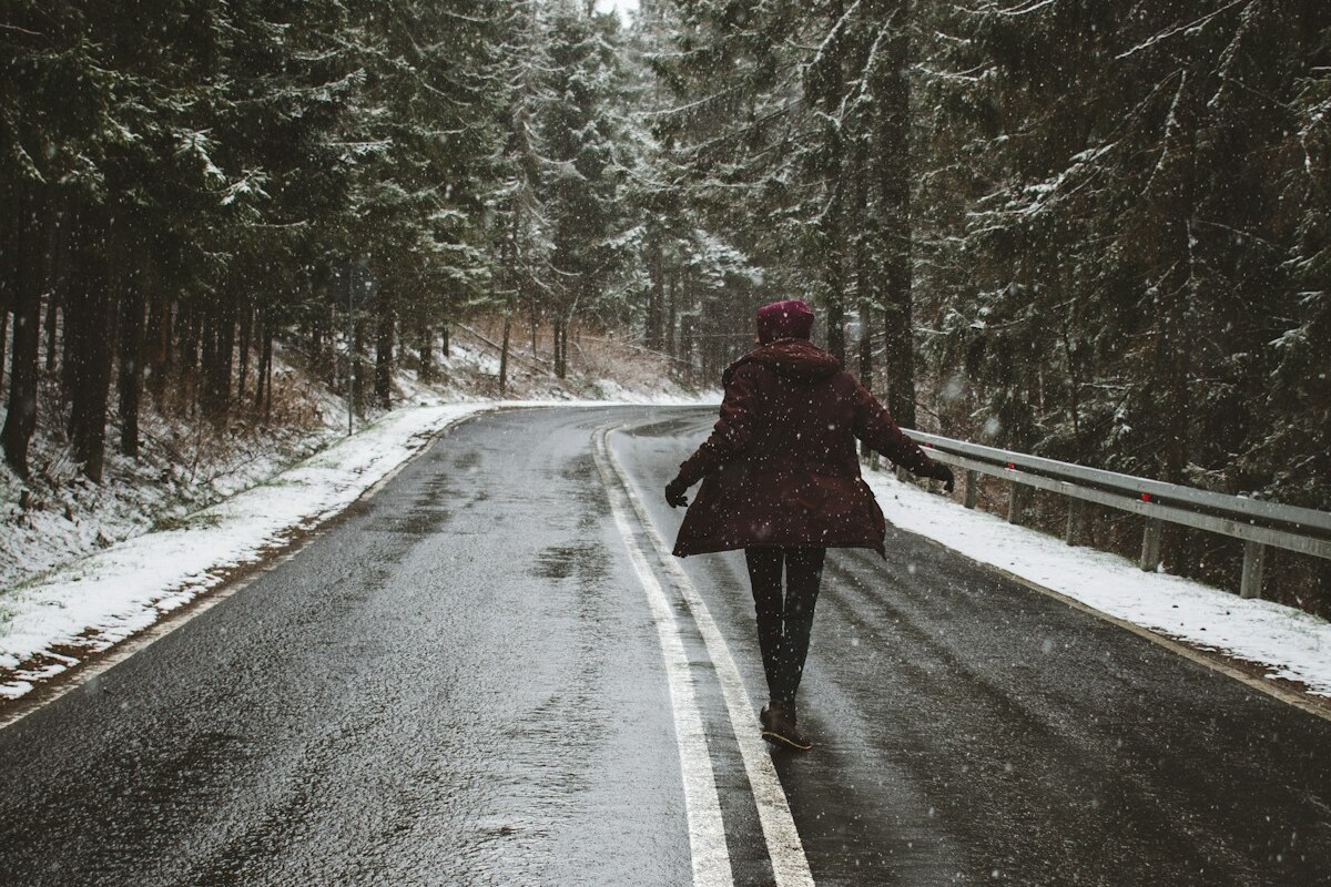 Juoksija lumisella tiellä